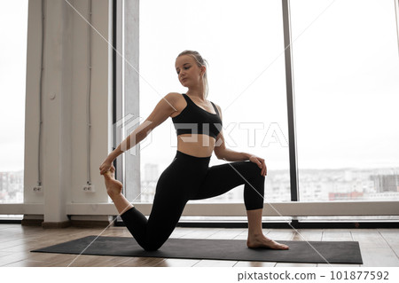 Yogini taking up Low Crescent Lunge Pose in yoga studio Yogini taking up Low Crescent Lunge Pose in yoga studio 101877592