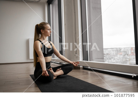 Lady doing Padmasana with gyan mudra in airy fitness studio Lady doing Padmasana with gyan mudra in airy fitness studio 101877595