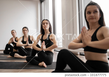 Yoga companions working out together in meditation room Yoga companions working out together in meditation room 101877775