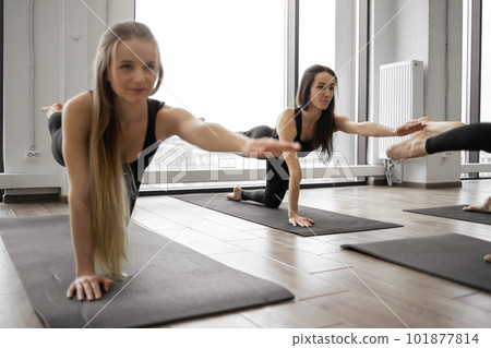 Women in Dandayamana Bharmenasana practicing yin yoga in studio 101877814