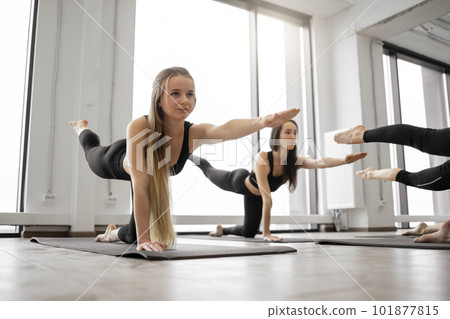 Women in Dandayamana Bharmenasana practicing yin yoga in studio 101877815