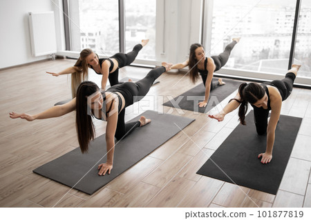 Adult yogis using Balancing Table Pose during yoga workout 101877819