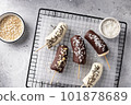 frozen bananas in dark and white chocolate on cooling rack. Healthy vegan dessert concept. top view 101878689