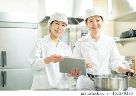 A woman who cooks while looking at a tablet A woman who cooks while looking at a tablet 101879339