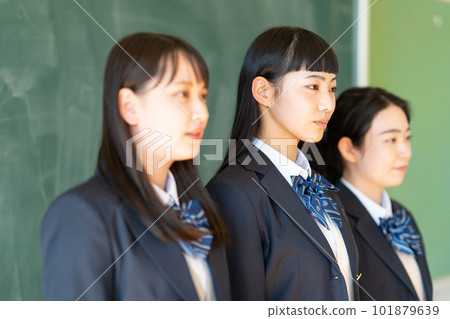 A high school girl in uniform standing in front of a blackboard A high school girl in uniform standing in front of a blackboard 101879639