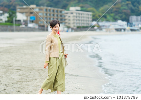 Middle-aged woman walking on the beach 101879789