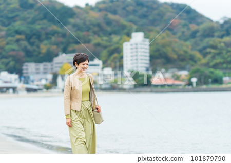 Middle-aged woman walking on the beach Middle-aged woman walking on the beach 101879790