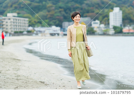 Middle-aged woman walking on the beach Middle-aged woman walking on the beach 101879795