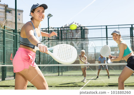 Two young sporty girls playing padel game in court on sunny day 101880260