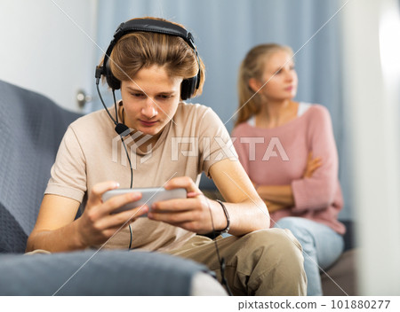 Teen boy with smartphone not paying attention to upset mother 101880277
