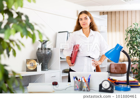 Clerical worker with folder in hands standing in office 101880461
