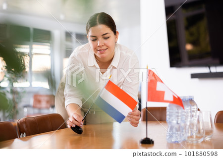 female assistant prepares conference room for diplomats of Switzerland and Netherlands female assistant prepares conference room for diplomats of Switzerland and Netherlands 101880598