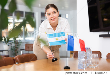 female assistant prepares conference room for diplomats of Argentina and France 101880643