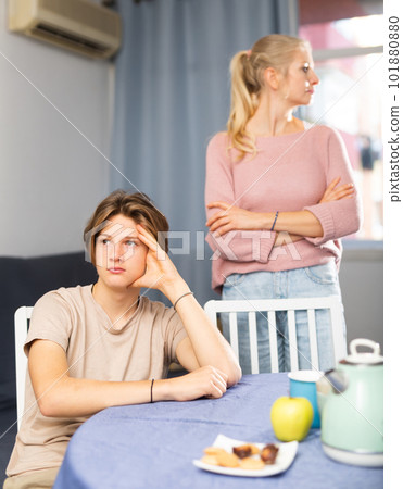 Offended teenager sitting at home table after disagreements with mom 101880880