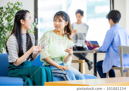 Two women operating smartphones in a cafe 101881154