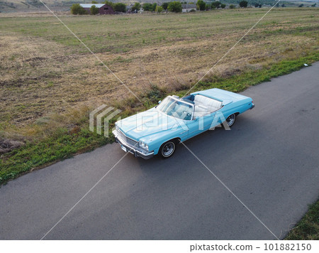 Blue car parked on the road against the background of the sunny sky. Retrocar Blue car parked on the road against the background of the sunny sky. Retrocar 101882150
