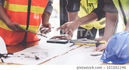Architect and Engineer working with blueprints for architectural plan, engineer sketching a construction project, green energy concept 101882246