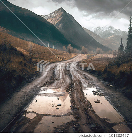 An unpaved dirt road leading to a mountain with an outdoor feeling, a muddy puddle and a cloudy sky 101882457