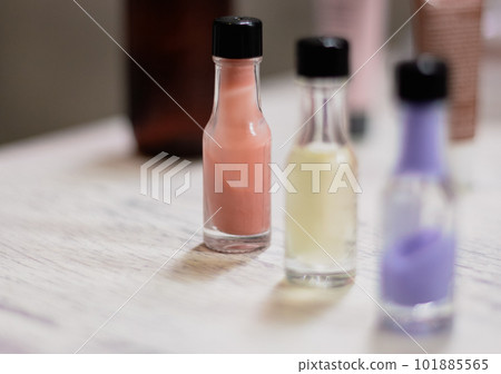 Three small bottles of colourful cream in a row with copy space. Wellness product on table. Bathroom concept. Cosmetic product. Healthy lifestyles. Tonic and lotion in bottles. Three small bottles of colourful cream in a row with copy space. Wellness product on table. Bathroom concept. Cosmetic product. Healthy lifestyles. Tonic and lotion in bottles. 101885565