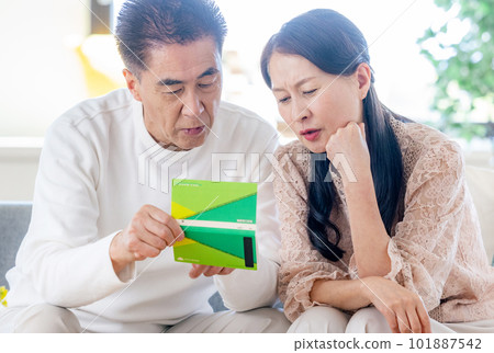 Senior couple looking at pension book Senior couple looking at pension book 101887542