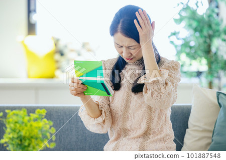 A woman who falls down looking at a passbook A woman who falls down looking at a passbook 101887548