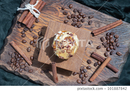 Caramel Pecanbon topped with decadent caramel frosting and pecans served with Cinnamon, Coffee beans on wooden. Caramel Pecanbon topped with decadent caramel frosting and pecans served with Cinnamon, Coffee beans on wooden. 101887842