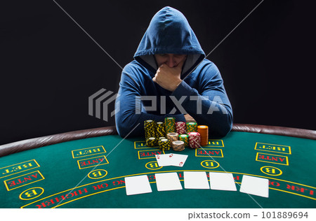 Portrait of a professional poker player sitting at pokers table Portrait of a professional poker player sitting at pokers table 101889694