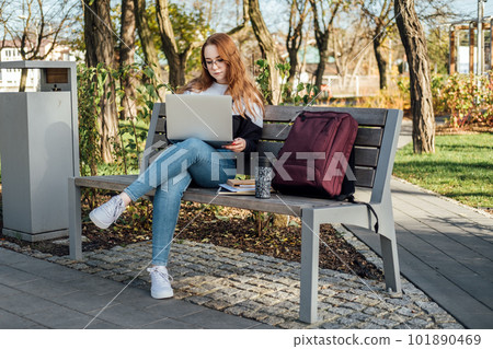 Artificial Intelligence AI in education industry. Applications of Artificial Intelligence and chatbots in Education. Student girl with laptop using chatbot for studying process 101890469