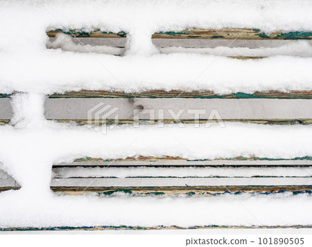 top view of snow-covered planks of wooden bench 101890505