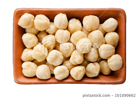 Hazelnuts in clay bowl isolated on white flat lay view 101890662