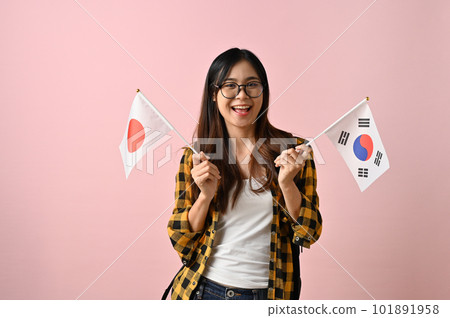 Pretty Asian female college student holding the flags of Japan and Korea. Exchange student Pretty Asian female college student holding the flags of Japan and Korea. Exchange student 101891958