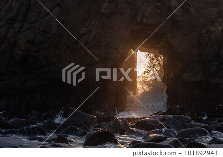 Setting sun peeping through keyhole arch Setting sun peeping through keyhole arch 101892941
