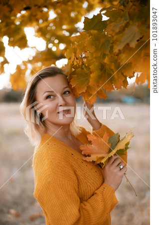 Woman holding autumn leafs in the nature. Autumn woman on leafs background 101893047