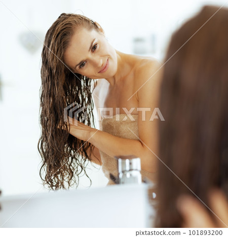 Young woman with long wet hair in bathroom 101893200