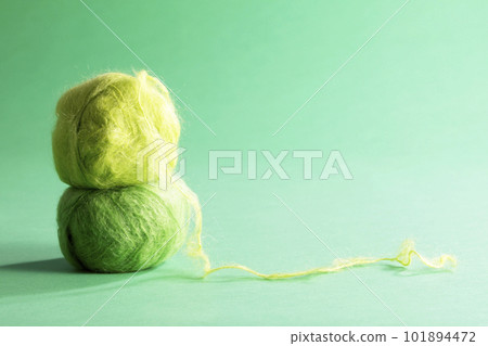 在綠色背景下拍攝的綠色馬海毛紗球 在綠色背景下拍攝的綠色馬海毛紗球 101894472