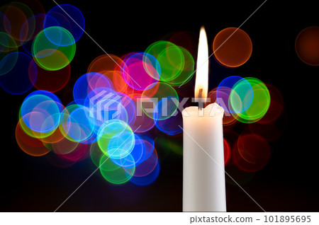 festive candle on a black background with colorful lights 101895695