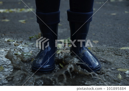 Person in rubber boots outdoor in rainy weather Person in rubber boots outdoor in rainy weather 101895884