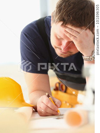 Pensive architect builder engineer thinks over blueprint 101896305
