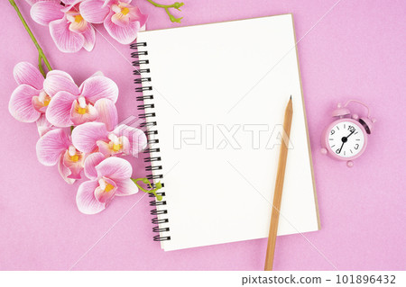 The blank open notebook and clock with pink color orchid for your text or message. 101896432
