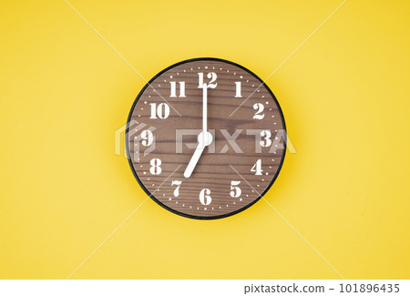 The Retro wooden clock at 7 O' clock on yellow color background. 101896435