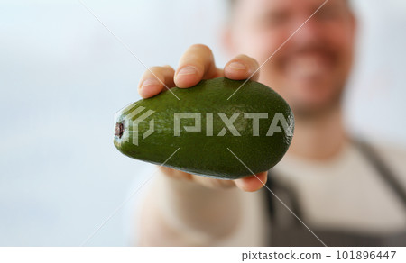 Cook holds fresh juicy green avocado in hands closeup 101896447