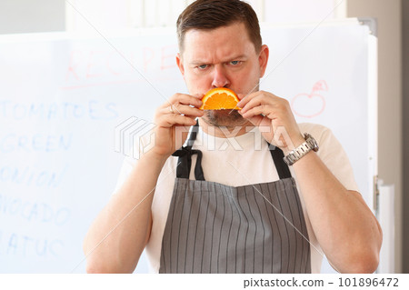 Angry sad male cook with orange slice frown 101896472