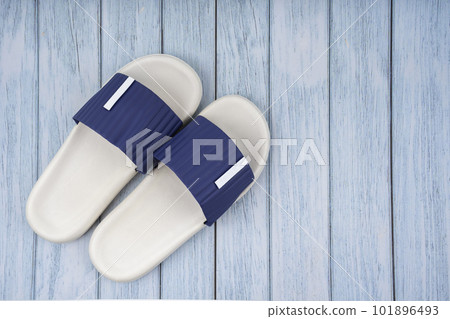 The Top view of white and blue color rubber slipper shoes on blue wooden background with copy space. Summer holiday vacation concept. The Top view of white and blue color rubber slipper shoes on blue wooden background with copy space. Summer holiday vacation concept. 101896493