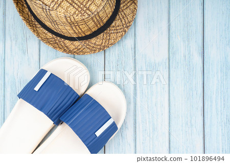 The Blue sandals and straw hat with copy-space on blue wooden background. The Blue sandals and straw hat with copy-space on blue wooden background. 101896494