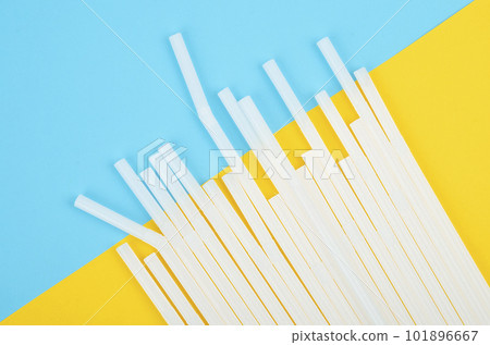 white plastic drinking straws on blue and yellow background. Garbage Environment pollustion concept. white plastic drinking straws on blue and yellow background. Garbage Environment pollustion concept. 101896667