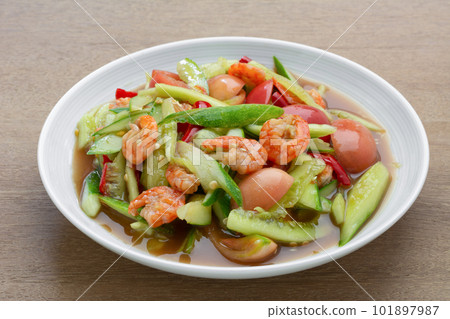 close up of thai style spicy cucumber salad in a ceramic dish on wooden table. asian homemade food concept. 101897987