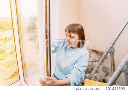 Active Seniors Concept. Happy Shy Cheerful Smiling Mature Woman Cleaning Window. Concept Of Household And People In Retirement. Caucasian Woman Middle Age. Elderly Woman Cleaning Apartment. Housewife 101898693