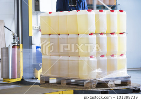 The machine for packing cellophane. Plastic jars wrapped in cellophane 101899739
