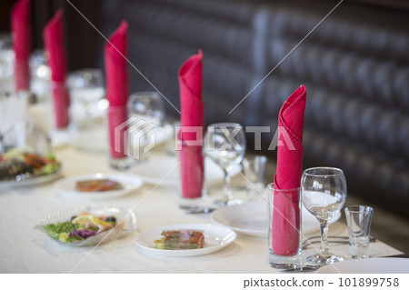 Table in the restaurant with appliances ready for the beginning of dinner Table in the restaurant with appliances ready for the beginning of dinner 101899758