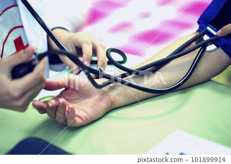 The doctor measures the pressure of the patient The doctor measures the pressure of the patient 101899914